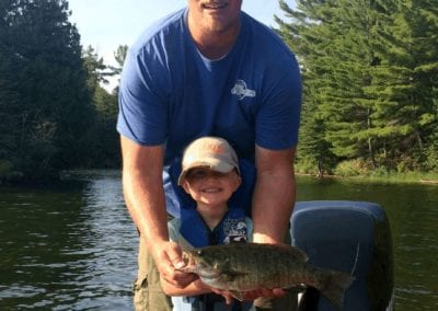 Kris with happy angler and smallmouth bass