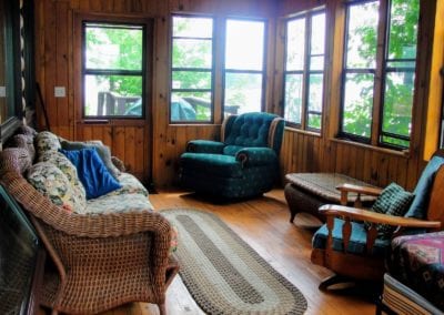 Screened porch with lake view at Point guest cabin