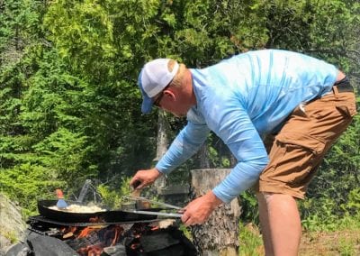 Fishing Guides cooking fresh fish over shore lunch camp fire