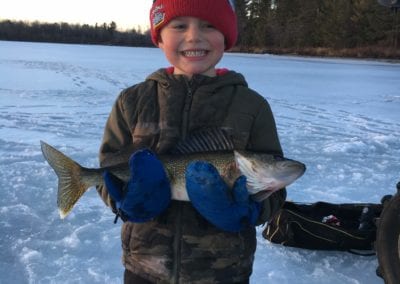 Young angler ice fishing walleye on the Manitou