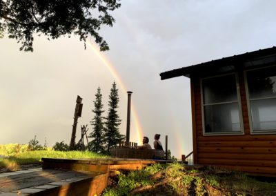 Rainbow in sky over hot tub and sauna